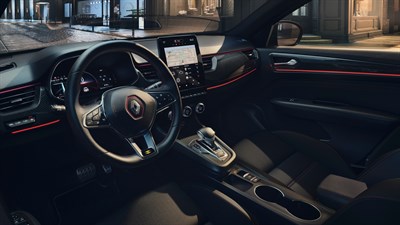 the inside of the renault arkana car. the seats a new touch screen and a salon with red details