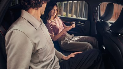 one man and one woman sitting in the backseats of the renault arkana