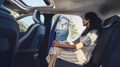 a woman is sitting in the back seats of a car.